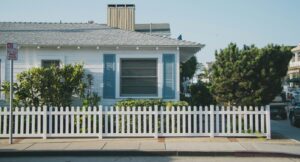 white and blue house beside fence