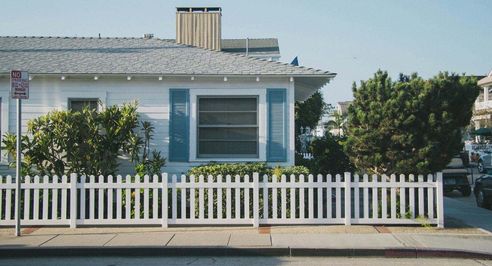 white and blue house beside fence